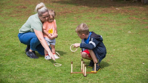 A young girl playing quoits on a lawn